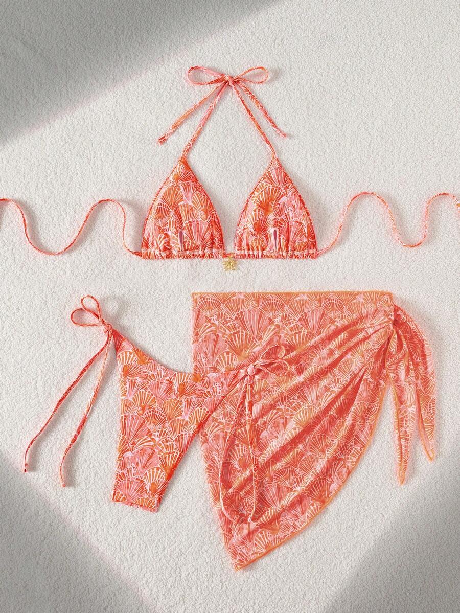 Women's 3-piece blue tropical shell print bikini set featuring a halter bralette top, low-waist tie-side bottom, and a matching sheer mesh cover-up skirt.