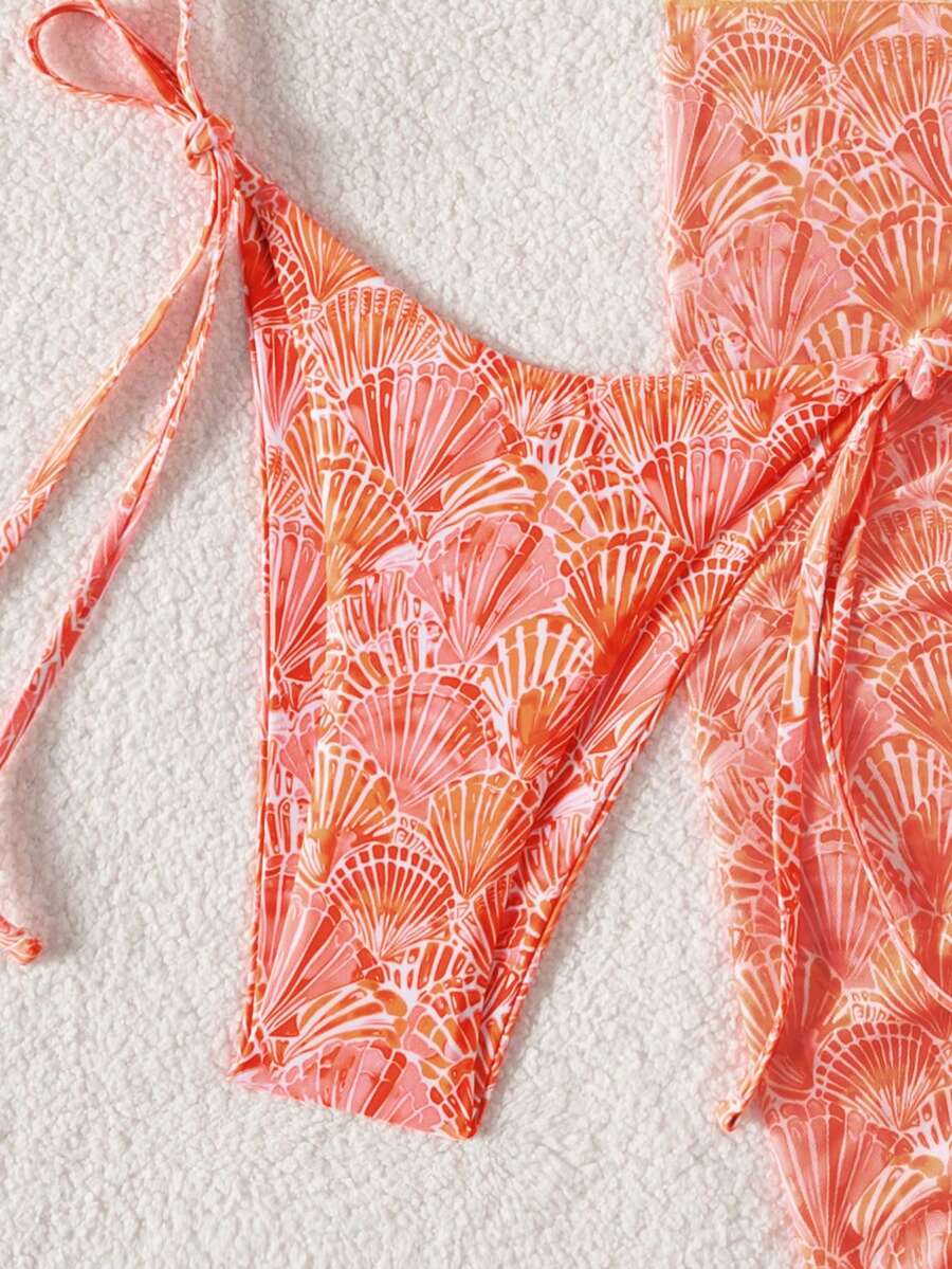 Women's 3-piece blue tropical shell print bikini set featuring a halter bralette top, low-waist tie-side bottom, and a matching sheer mesh cover-up skirt.