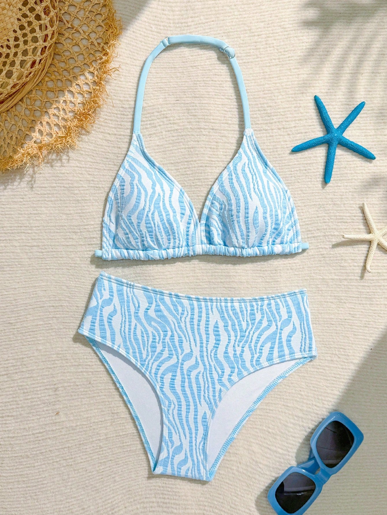 Tween girls blue and white striped two-piece bikini set with halter triangle top and mid-waist short bikini bottoms for beach and vacation swimwear.