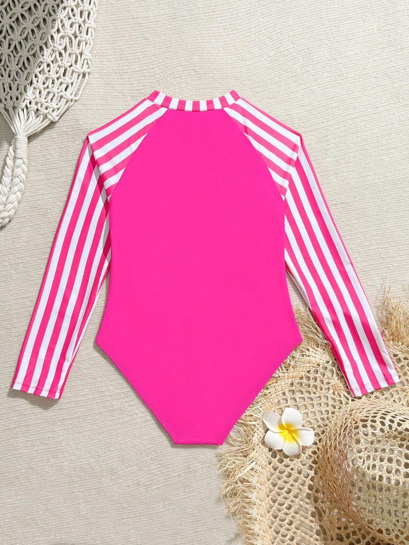 Tween girls one-piece rash guard swimsuit with long sleeves, high neck, front zipper, and ocean shell graphic print in a fitted style for beach, swimming, and vacation wear.