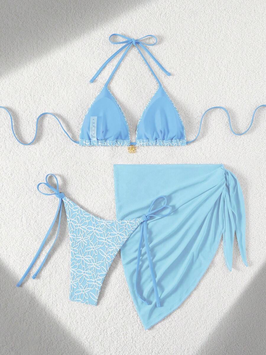Women's 3-piece blue tropical shell print bikini set featuring a halter bralette top, low-waist tie-side bottom, and a matching sheer mesh cover-up skirt.