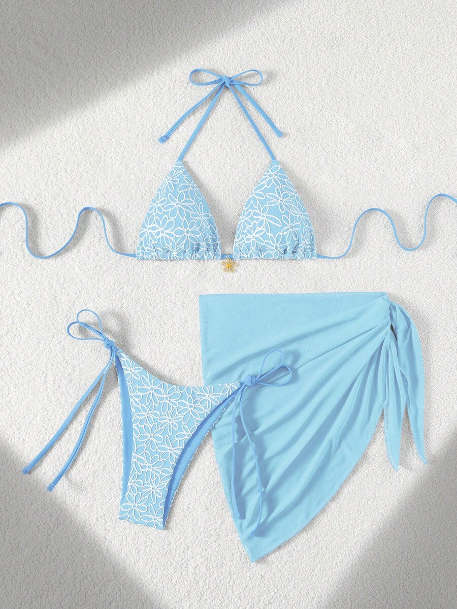 Women's 3-piece blue tropical shell print bikini set featuring a halter bralette top, low-waist tie-side bottom, and a matching sheer mesh cover-up skirt.