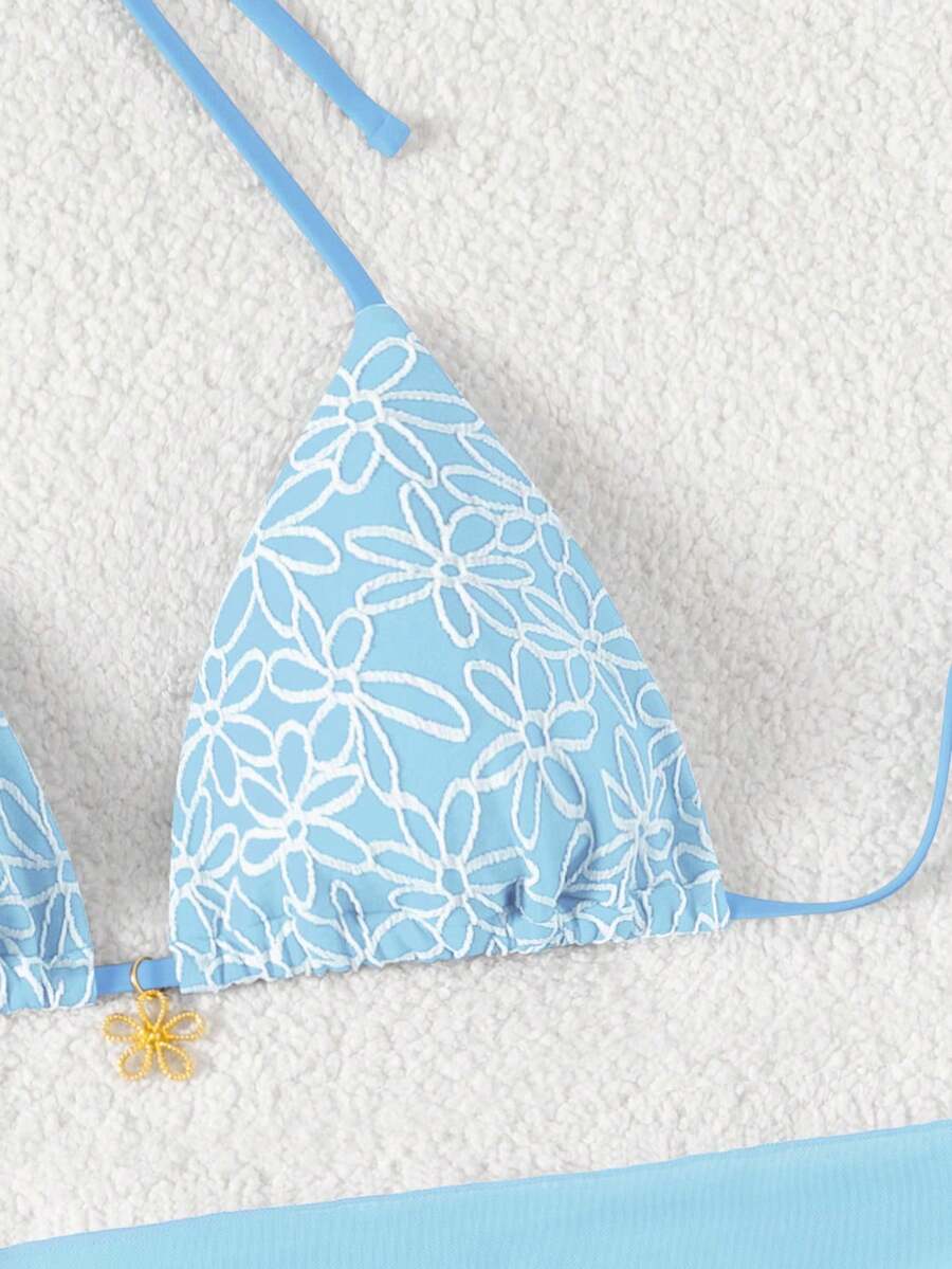 Women's 3-piece blue tropical shell print bikini set featuring a halter bralette top, low-waist tie-side bottom, and a matching sheer mesh cover-up skirt.