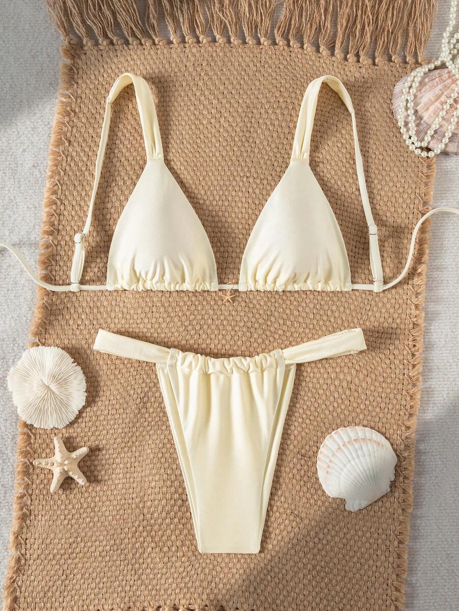 Women's 2-piece triangle cup bikini set in solid color featuring woven pearl shell decoration, halter neckline, and high-waist side-tie ruched bottoms.