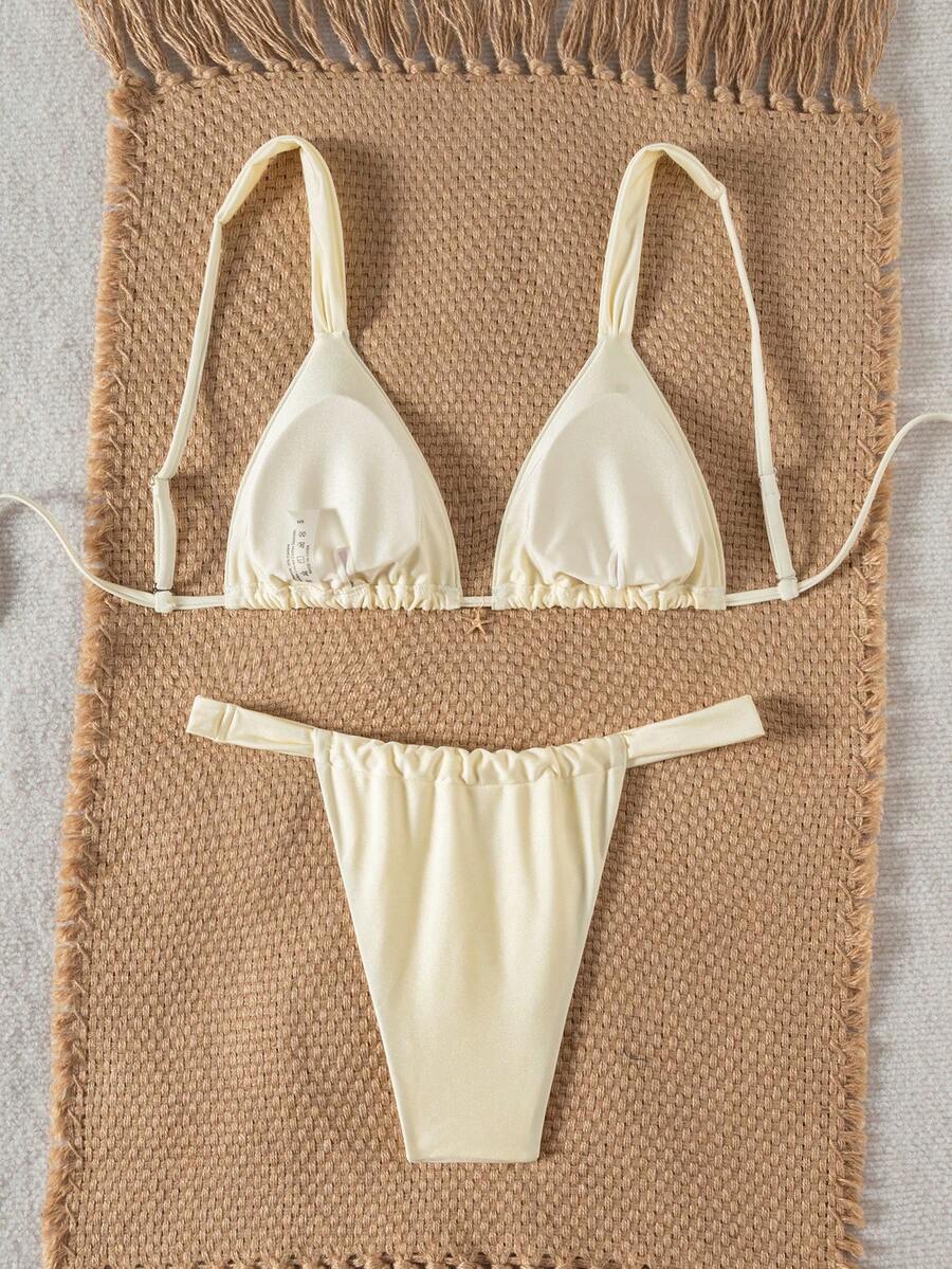 Women's 2-piece triangle cup bikini set in solid color featuring woven pearl shell decoration, halter neckline, and high-waist side-tie ruched bottoms.