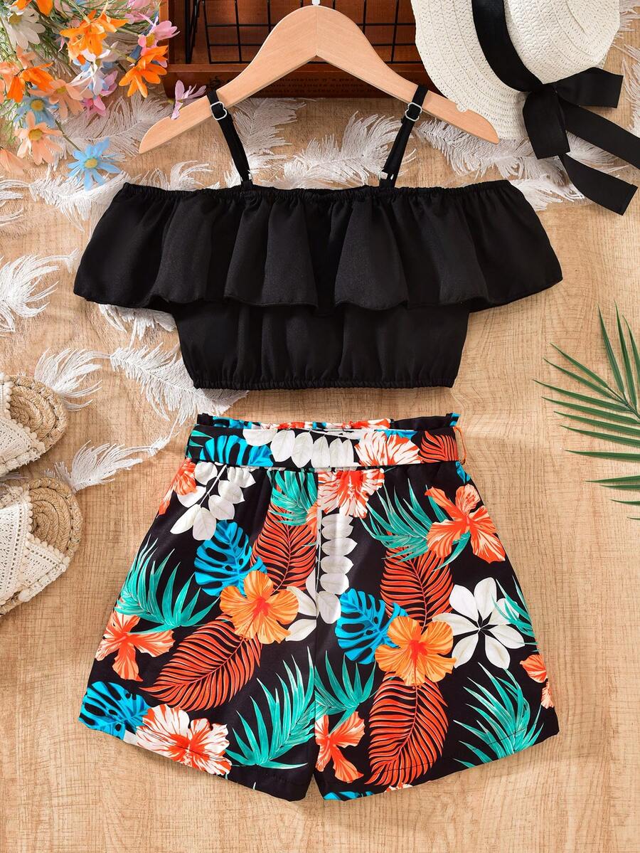 Tween girls 2-piece summer set featuring a black off-shoulder crop top with spaghetti straps and tropical leaf print ruffled paperbag waist shorts with a matching belt.