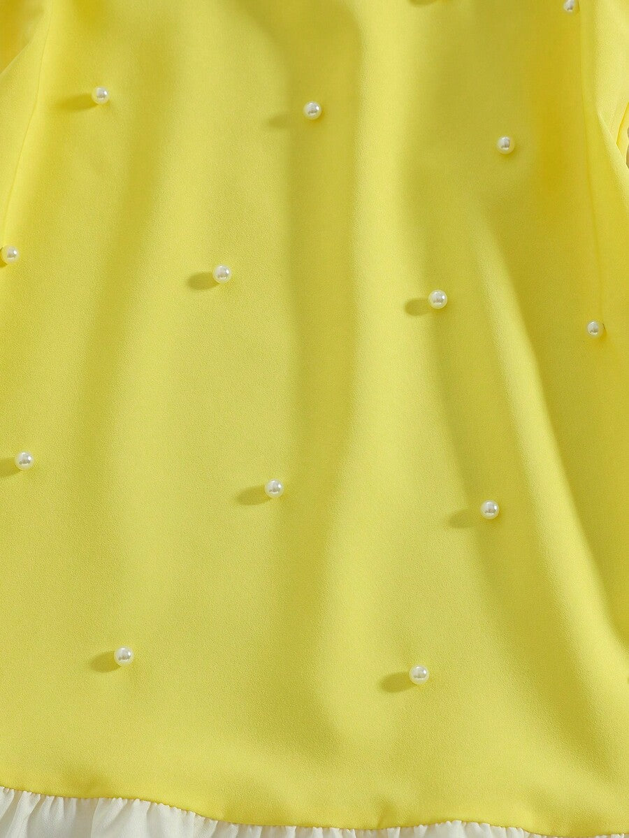 Yellow sleeveless colorblock dress for girls featuring a round neck, ruffle hem, and front bow detail.