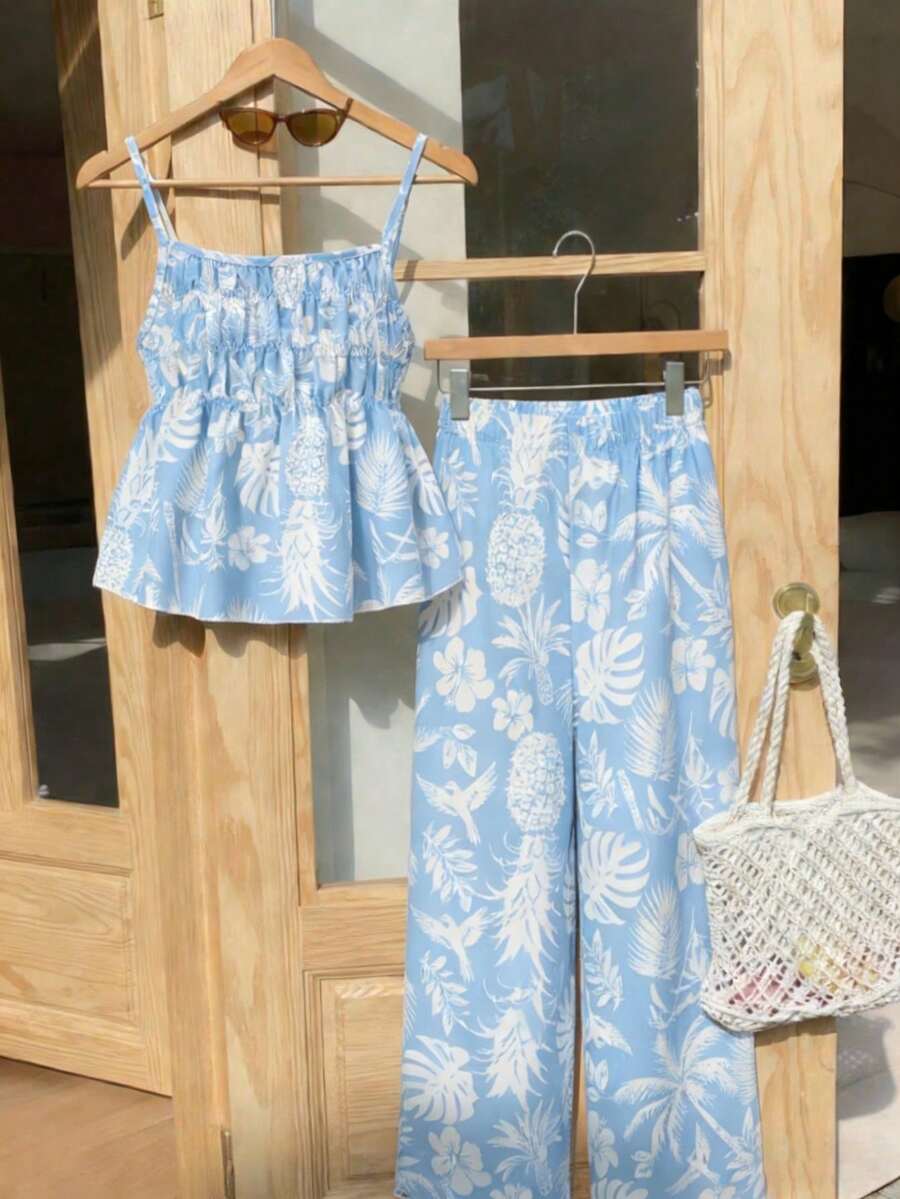 Tween girls light blue 2-piece summer vacation outfit featuring a plant print spaghetti strap camisole top with shirred ruffle hem and wide-leg long pants.