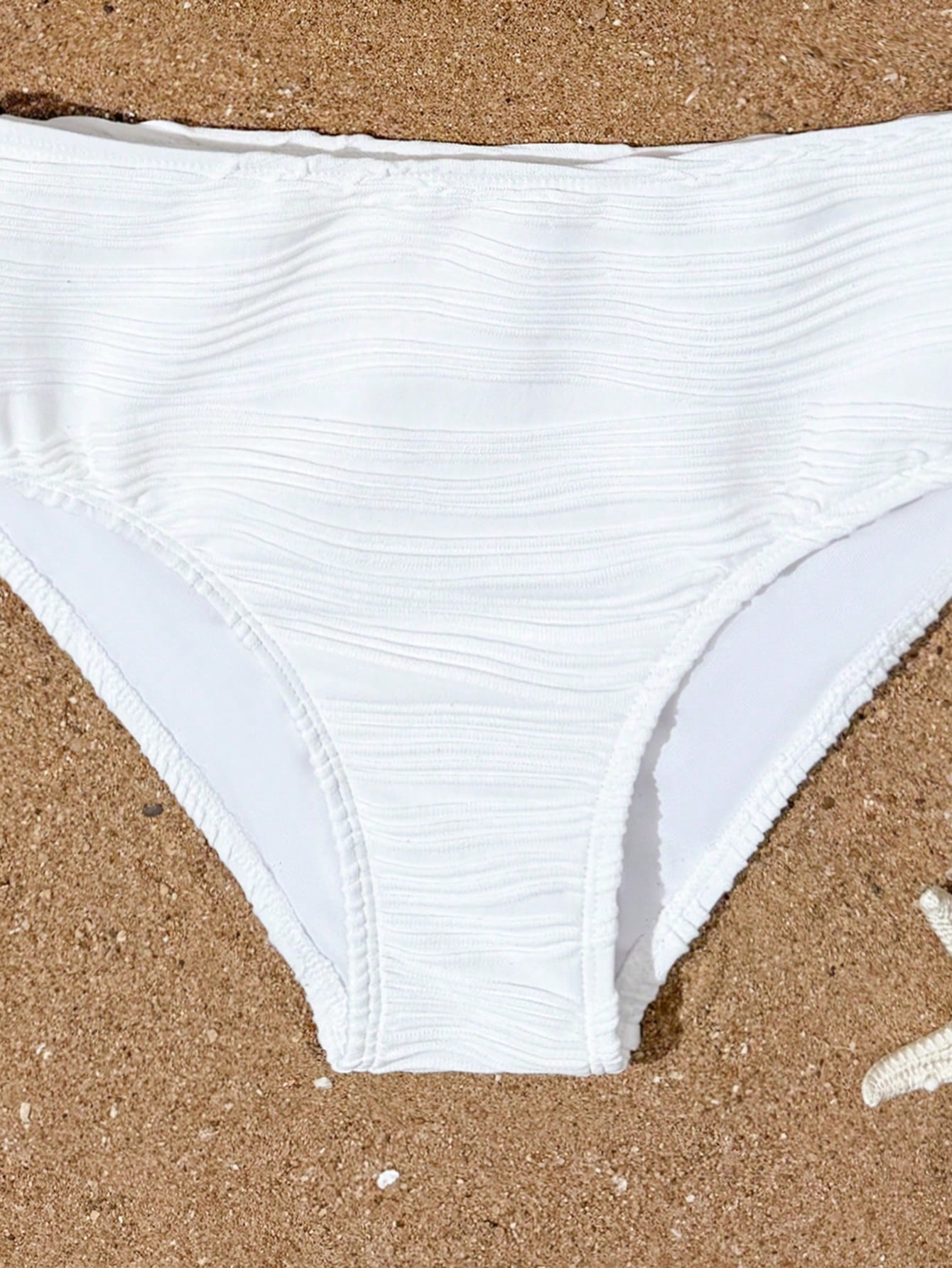 Tween girls 2-piece bikini swimwear set in black with a wave-pattern geometric design, featuring halter neckline, wireless top, and high-waist short bottoms with starfish and shell decor.