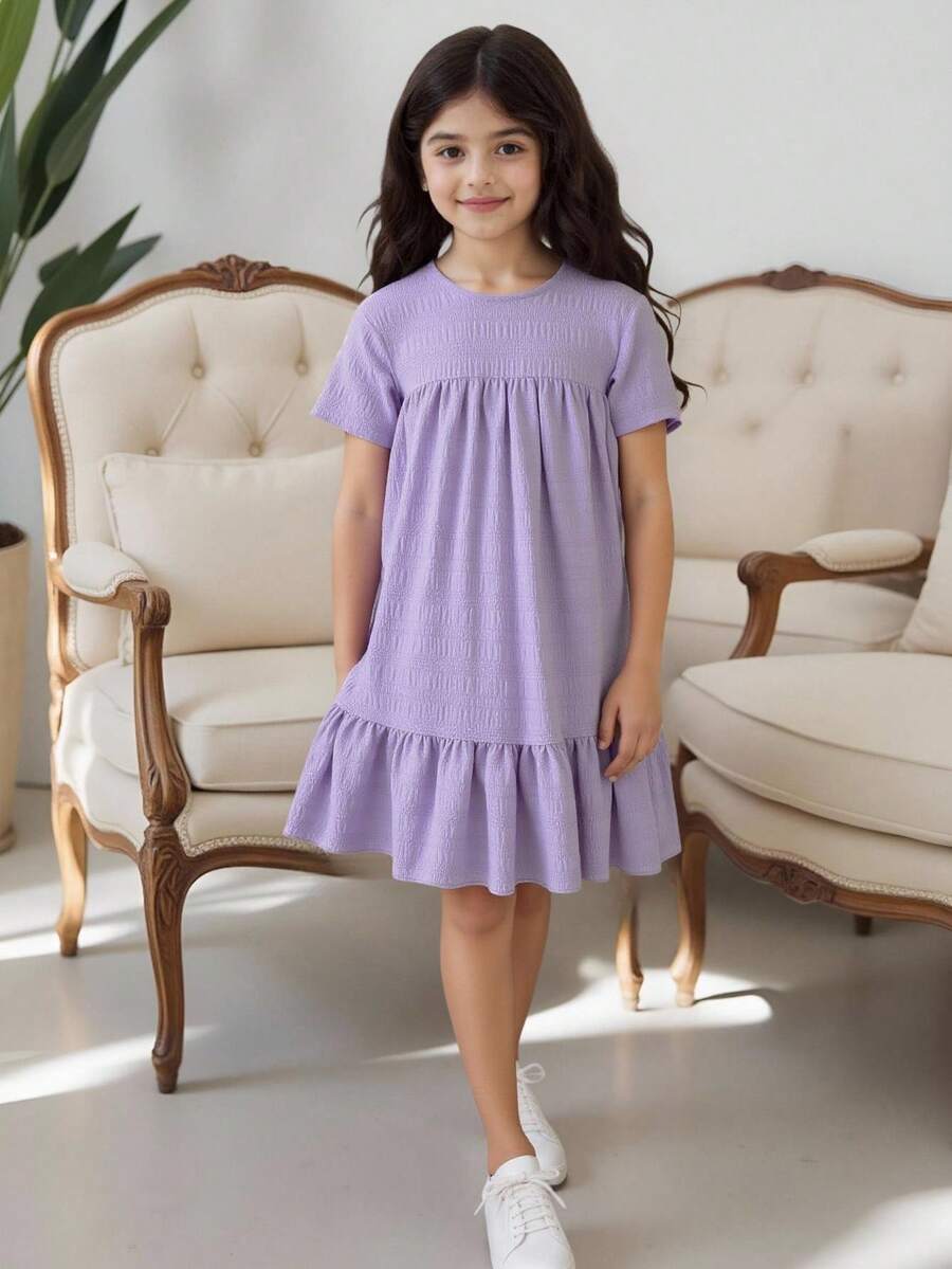 Tween girl wearing an Army Green textured short sleeve smock midi dress with round neck and ruffle flounce hem.