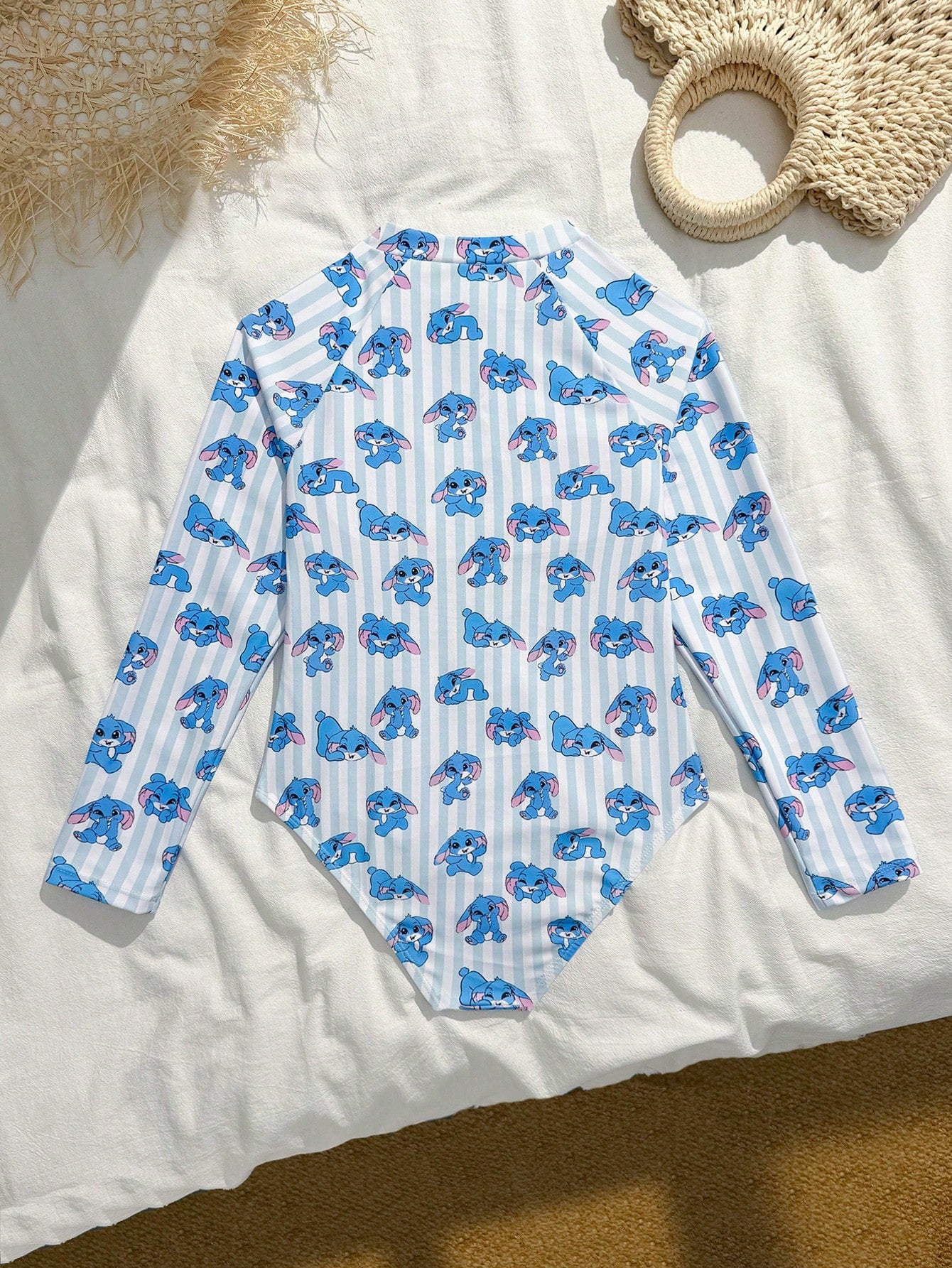 Girls one-piece swimsuit in blue with all-over leopard leaf print, ruffle detail, zipper front, high neck, and lined body for swimming and vacation.