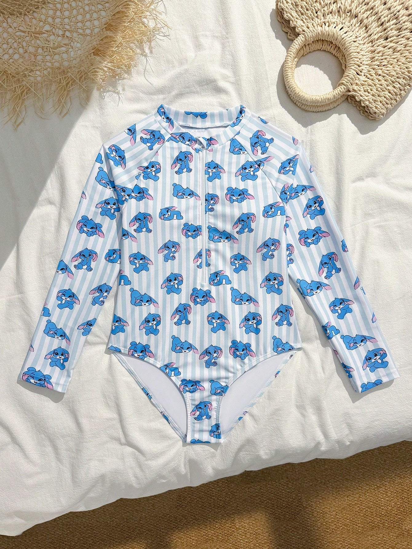 Girls one-piece swimsuit in blue with all-over leopard leaf print, ruffle detail, zipper front, high neck, and lined body for swimming and vacation.