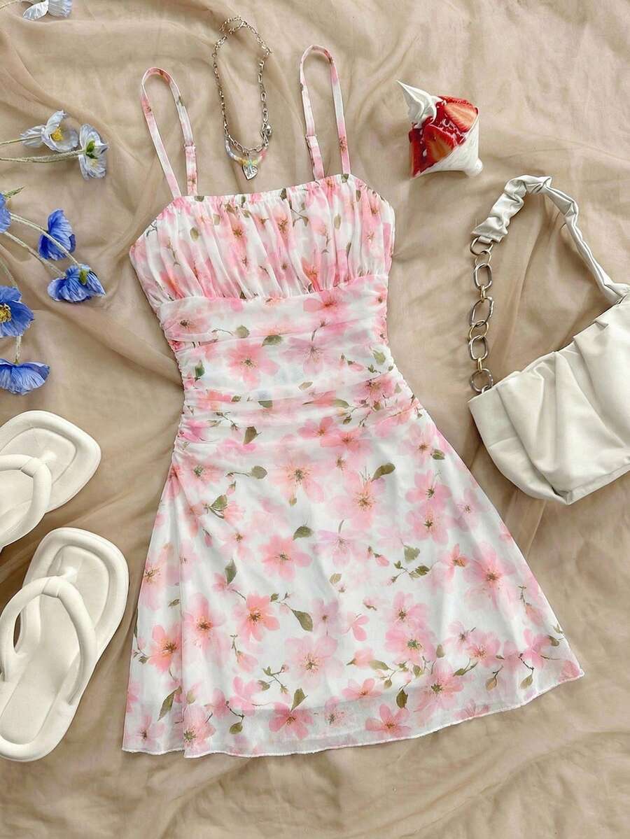 Tween girl yellow mini sundress with large pink floral hibiscus print, spaghetti straps, high waist, flared hem, and sleeveless cami style for summer beach wear