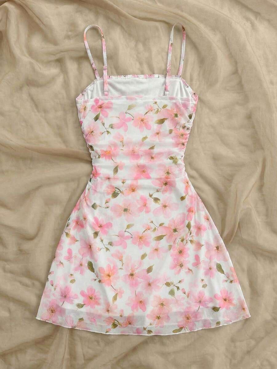 Tween girl yellow mini sundress with large pink floral hibiscus print, spaghetti straps, high waist, flared hem, and sleeveless cami style for summer beach wear