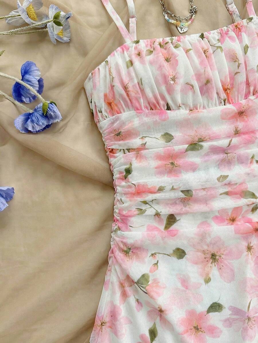 Tween girl yellow mini sundress with large pink floral hibiscus print, spaghetti straps, high waist, flared hem, and sleeveless cami style for summer beach wear