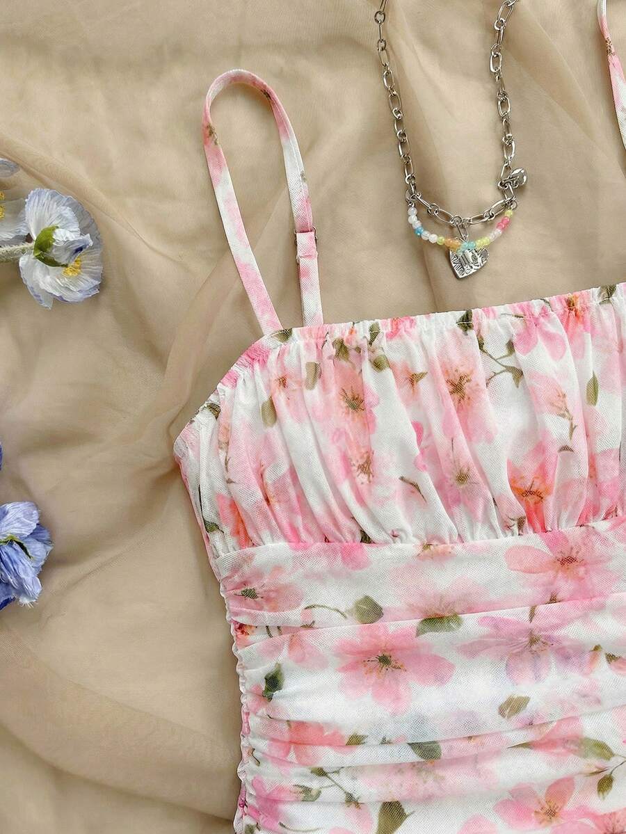Tween girl yellow mini sundress with large pink floral hibiscus print, spaghetti straps, high waist, flared hem, and sleeveless cami style for summer beach wear