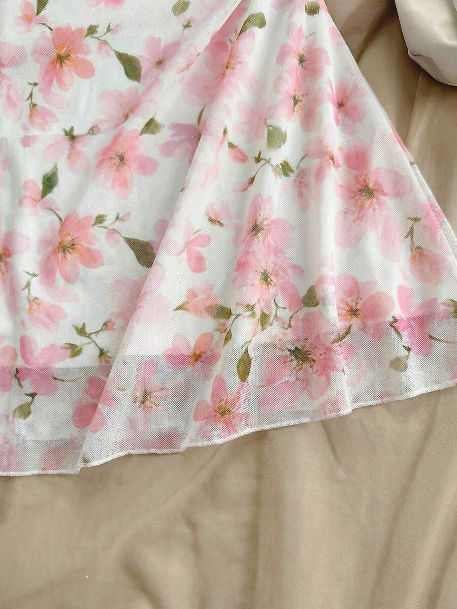 Tween girl yellow mini sundress with large pink floral hibiscus print, spaghetti straps, high waist, flared hem, and sleeveless cami style for summer beach wear