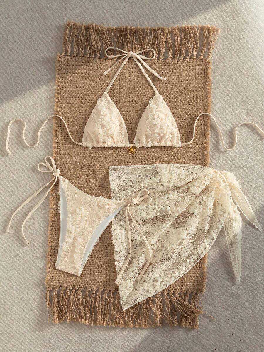 Women's 3-piece blue tropical shell print bikini set featuring a halter bralette top, low-waist tie-side bottom, and a matching sheer mesh cover-up skirt.