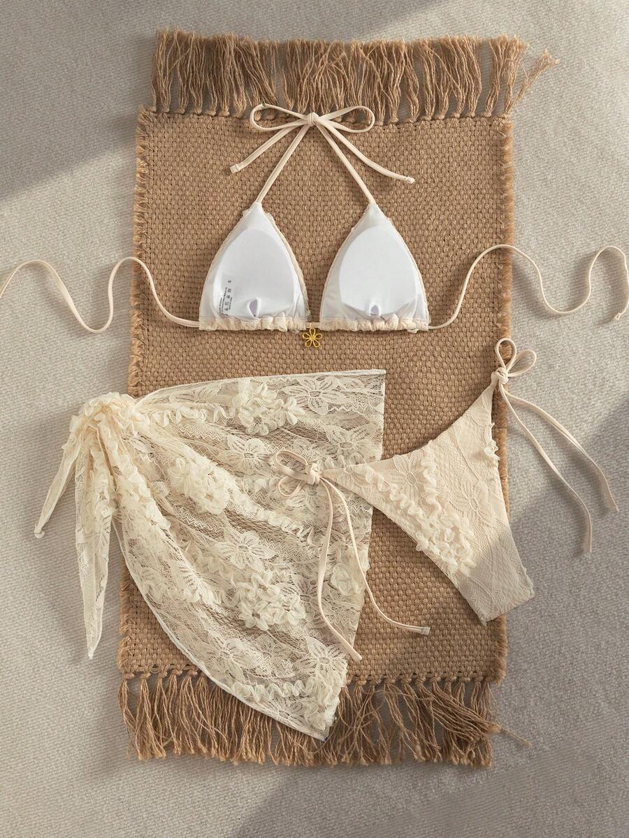 Women's 3-piece blue tropical shell print bikini set featuring a halter bralette top, low-waist tie-side bottom, and a matching sheer mesh cover-up skirt.