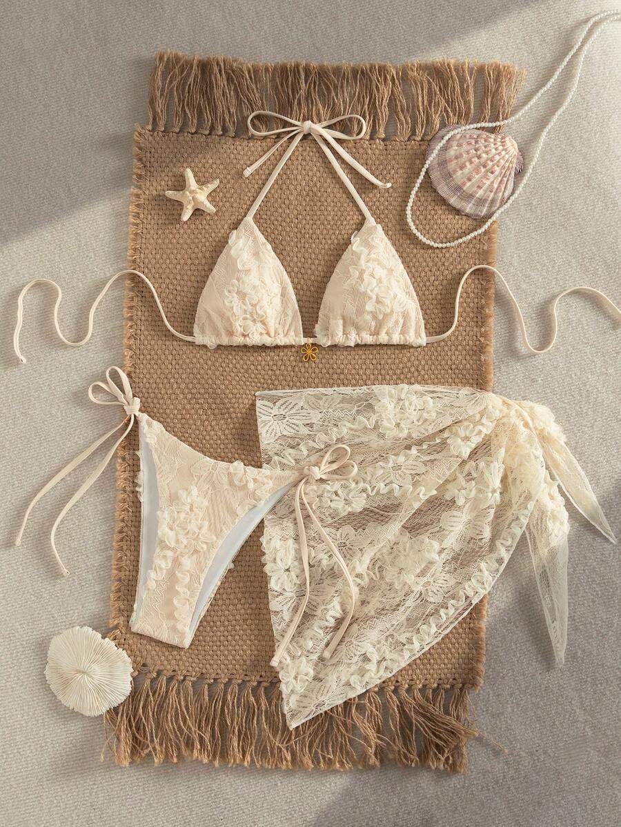 Women's 3-piece blue tropical shell print bikini set featuring a halter bralette top, low-waist tie-side bottom, and a matching sheer mesh cover-up skirt.