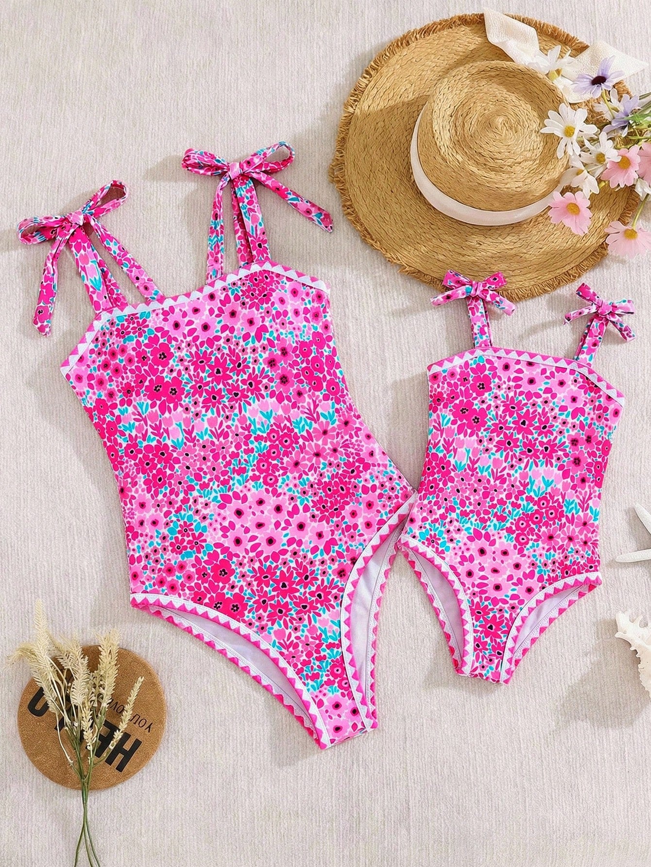 Tween girl floral print one-piece swimsuit with twist front, spaghetti straps, fitted shape, and multicolor all-over hibiscus-inspired pattern for beach and pool wear.