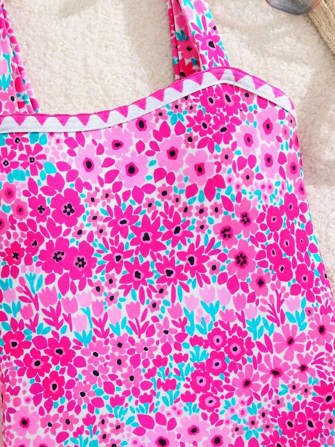 Tween girl floral print one-piece swimsuit with twist front, spaghetti straps, fitted shape, and multicolor all-over hibiscus-inspired pattern for beach and pool wear.