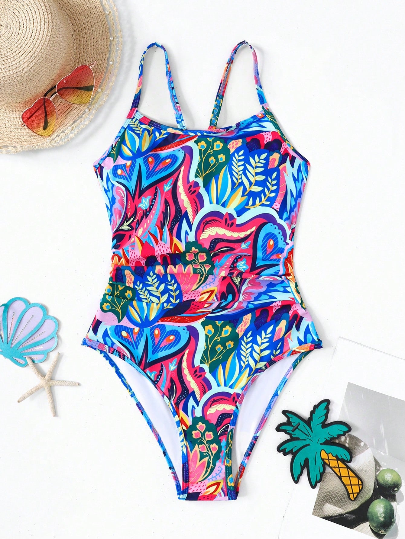 Pink allover print one-piece swimsuit for tween girls with spaghetti straps, lined body, wireless bra, and mid-waist bottom for beach or summer vacation.