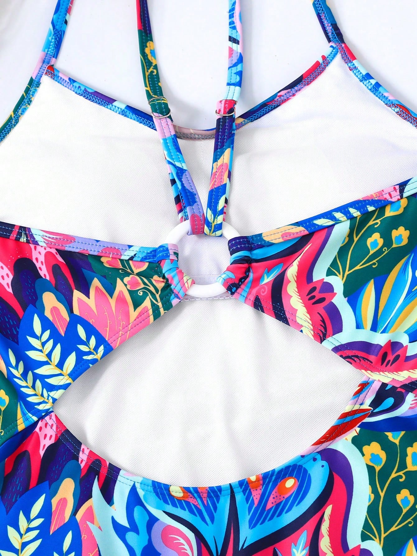 Pink allover print one-piece swimsuit for tween girls with spaghetti straps, lined body, wireless bra, and mid-waist bottom for beach or summer vacation.