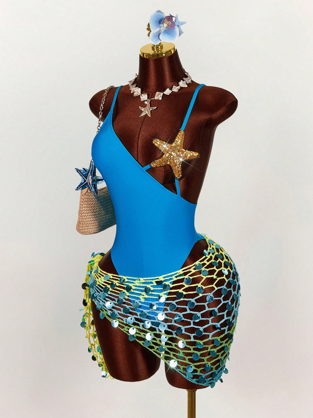 Women's blue one-piece swimsuit featuring a starfish bra splice design, asymmetrical neckline, and backless cutout details.