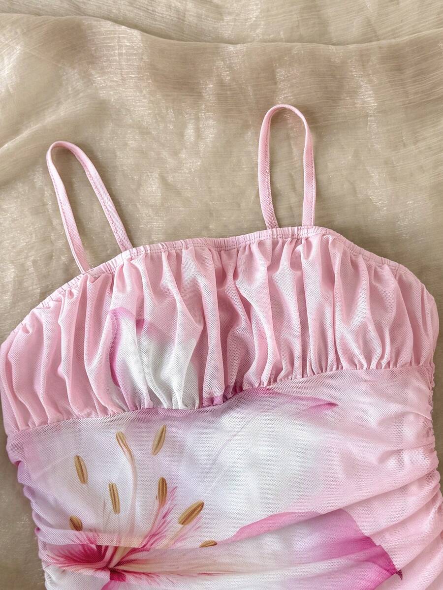 Tween girl yellow mini sundress with large pink floral hibiscus print, spaghetti straps, high waist, flared hem, and sleeveless cami style for summer beach wear