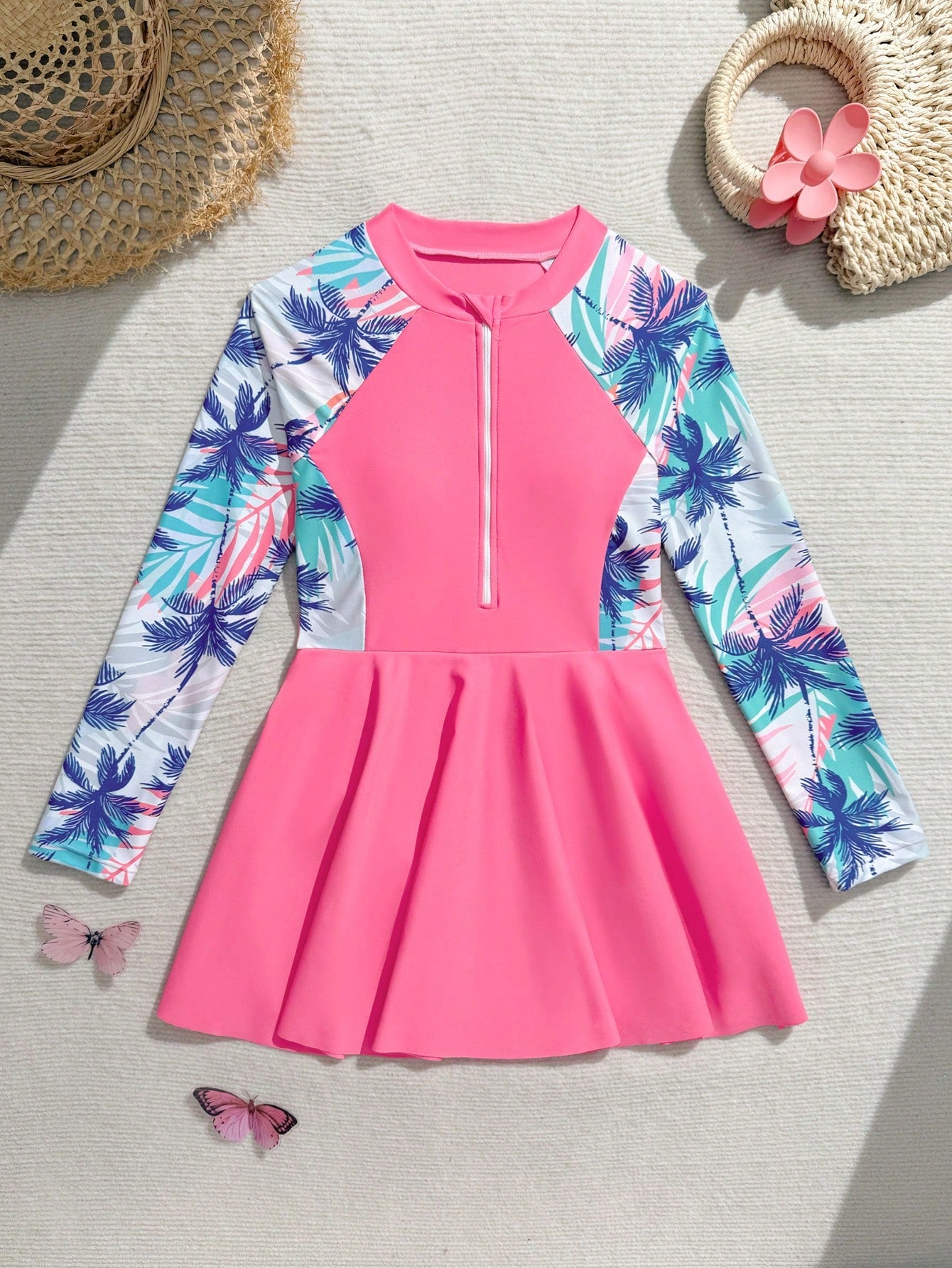 Tween girls one-piece swimsuit in black floral pattern with long sleeves, high neck, front zipper, and a skirt-style bottom.