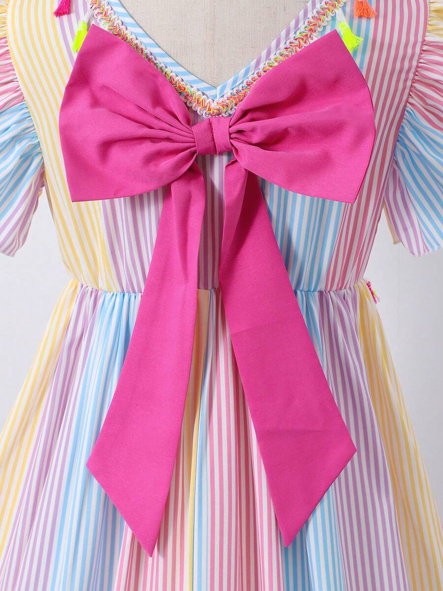 Tween girls blue short smock dress featuring flounce short sleeves, high waist flared hem, round neck, and front bow detail.