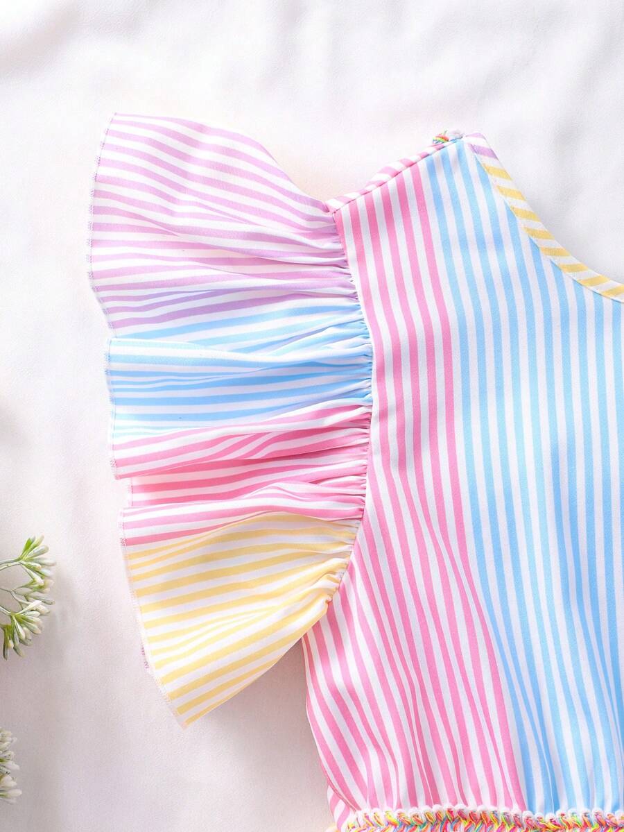 Tween girls blue short smock dress featuring flounce short sleeves, high waist flared hem, round neck, and front bow detail.