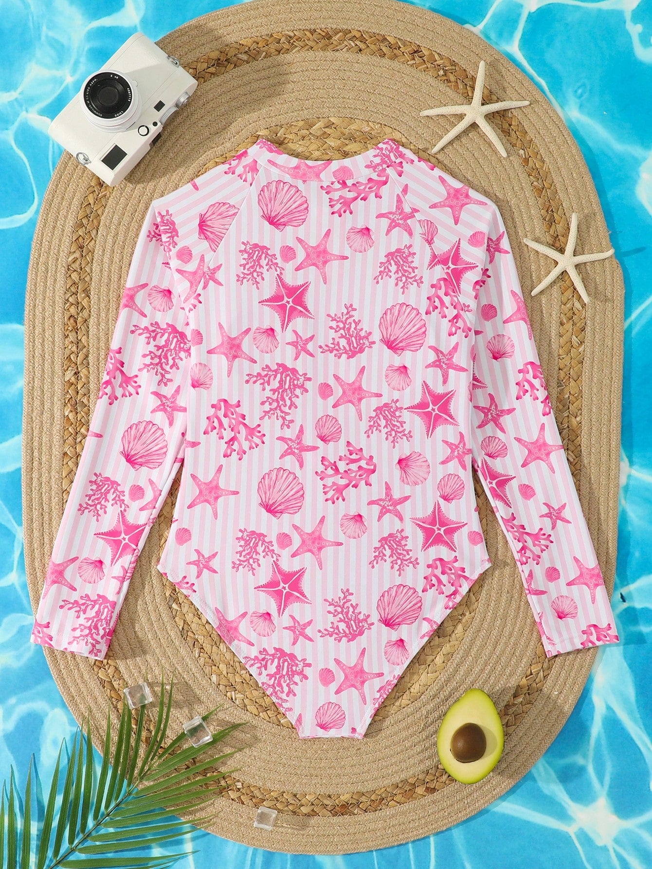 Tween girls one-piece rash guard swimsuit with long sleeves, high neck, front zipper, and ocean shell graphic print in a fitted style for beach, swimming, and vacation wear.