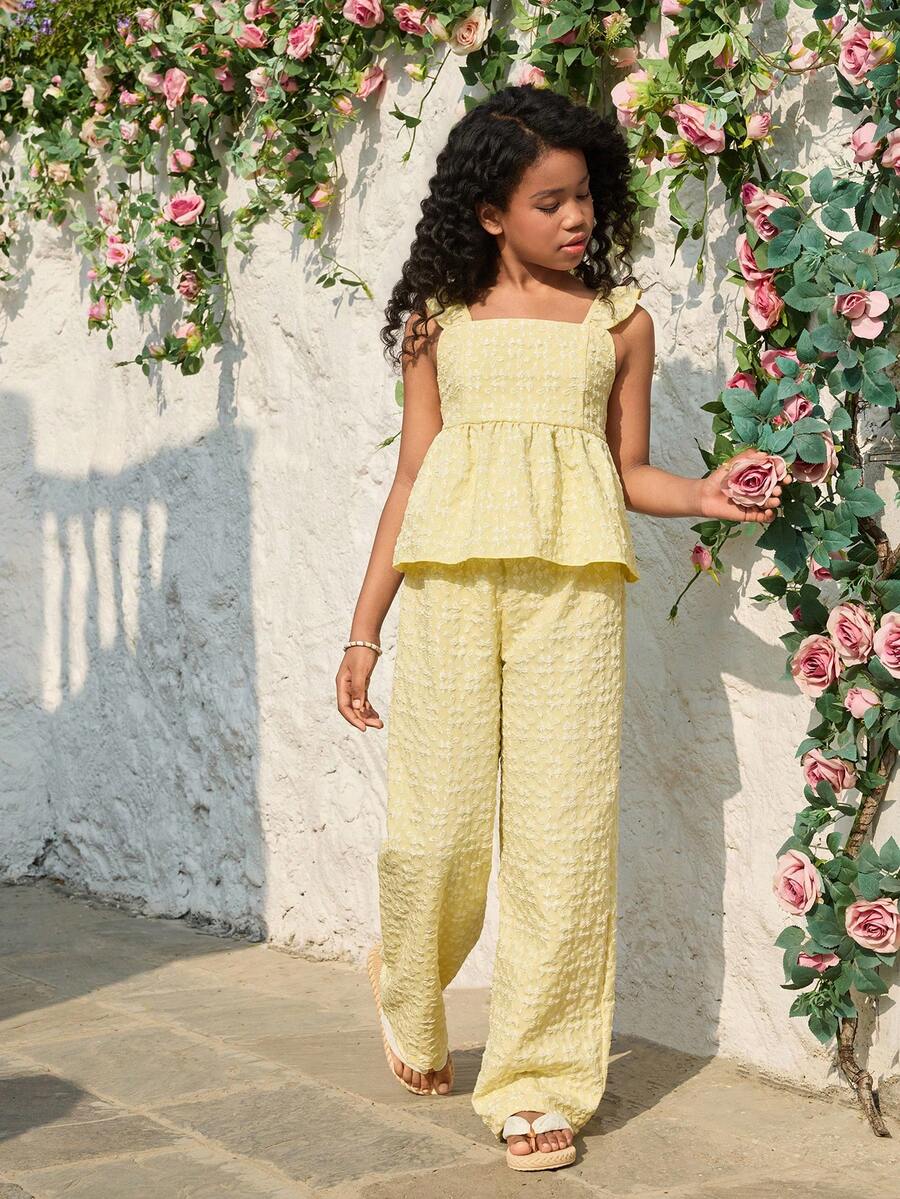 Tween girl wearing an apricot 2-piece outfit set featuring a shirred spaghetti strap short cami top and matching wide-leg long pants.