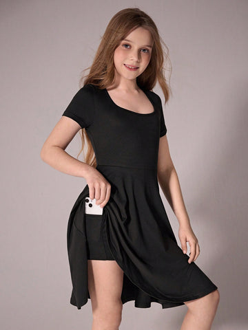 Tween girl wearing a casual black short sleeve knit mini dress with a round neck, high waist, and asymmetrical flared hem