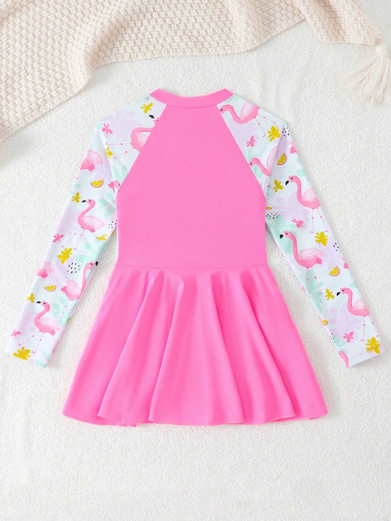 Tween girls one-piece swimsuit in black floral pattern with long sleeves, high neck, front zipper, and a skirt-style bottom.