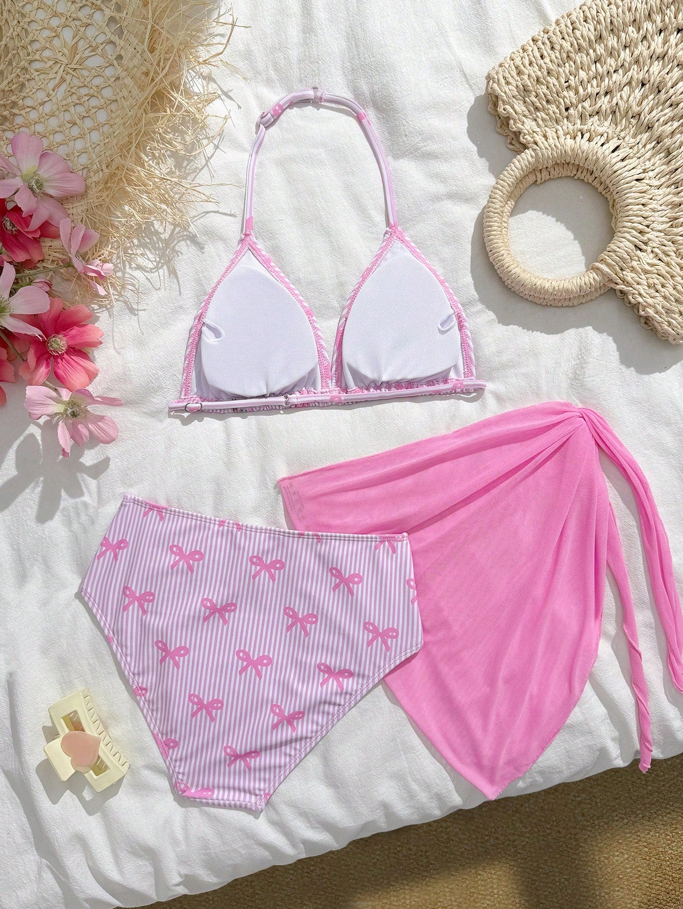 Tween girls 3-piece swimwear set in pink featuring a striped triangle halter bikini top with bow detail and adjustable neck and back ties, an adjustable mid-waist bikini bottom, and a sheer pink mesh skirt cover-up for beach or pool wear.