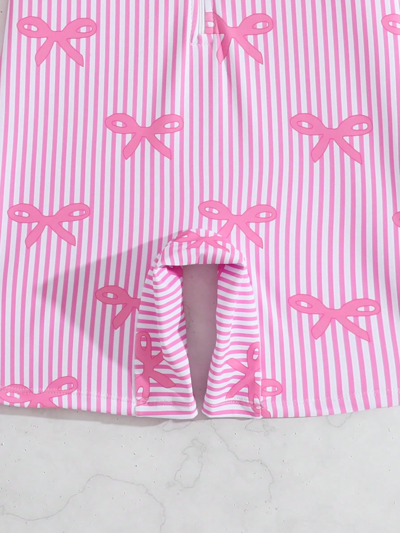 Tween girls one-piece swimsuit featuring a high neck, long sleeves, and shorts bottom, with a back zipper and strawberry plaid digital print on stretch knit fabric. Designed for swimming, vacation, and summer wear.