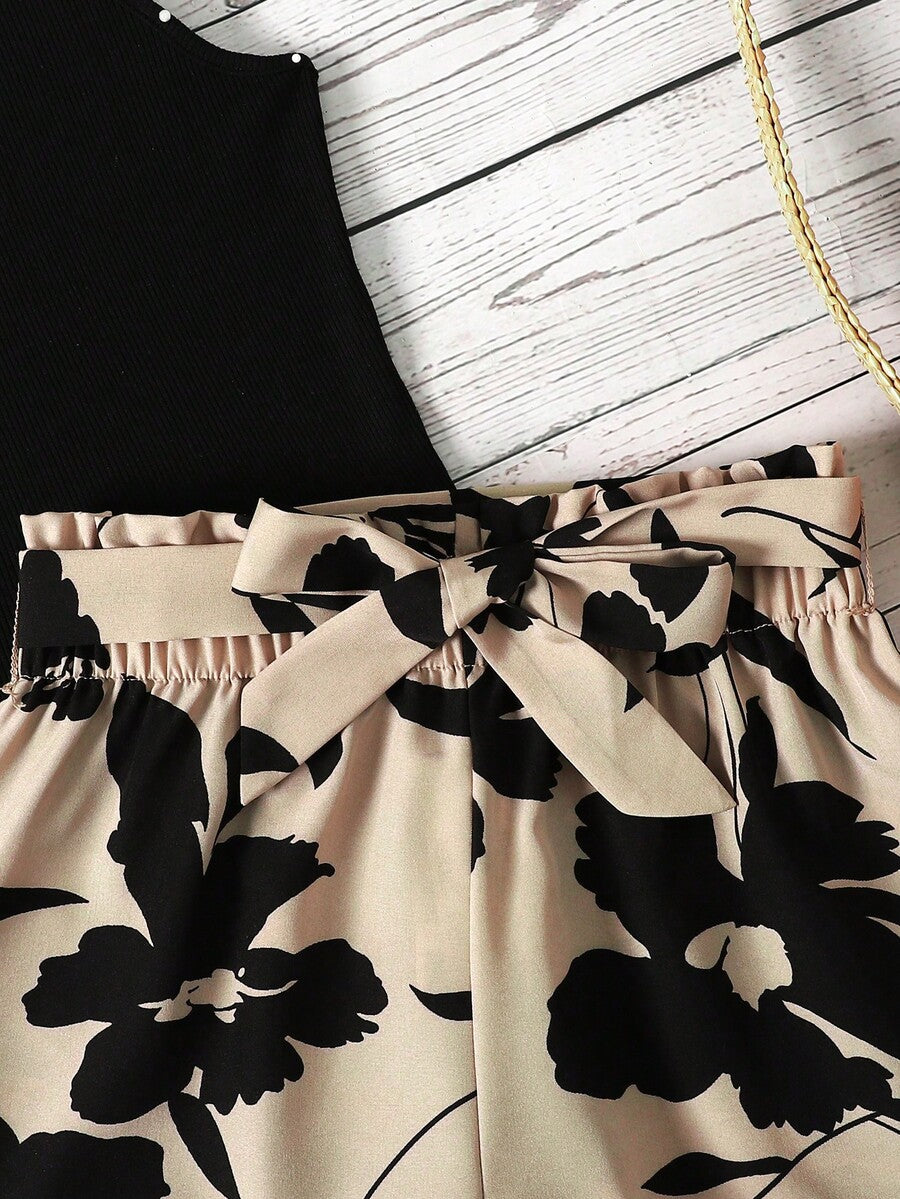 Tween girl wearing a casual 2-piece set featuring a black rib-knit scoop neck tank top and leopard print paperbag waist shorts with a matching belt.