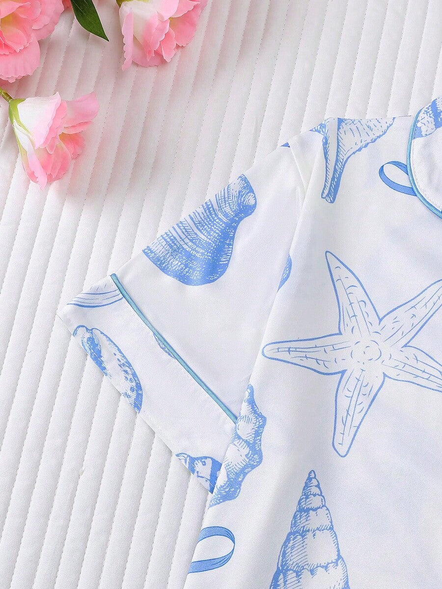 White 2-piece tween girl summer pajama set with blue ocean and seashell print featuring a short sleeve lapel cardigan top and matching elastic waist shorts.