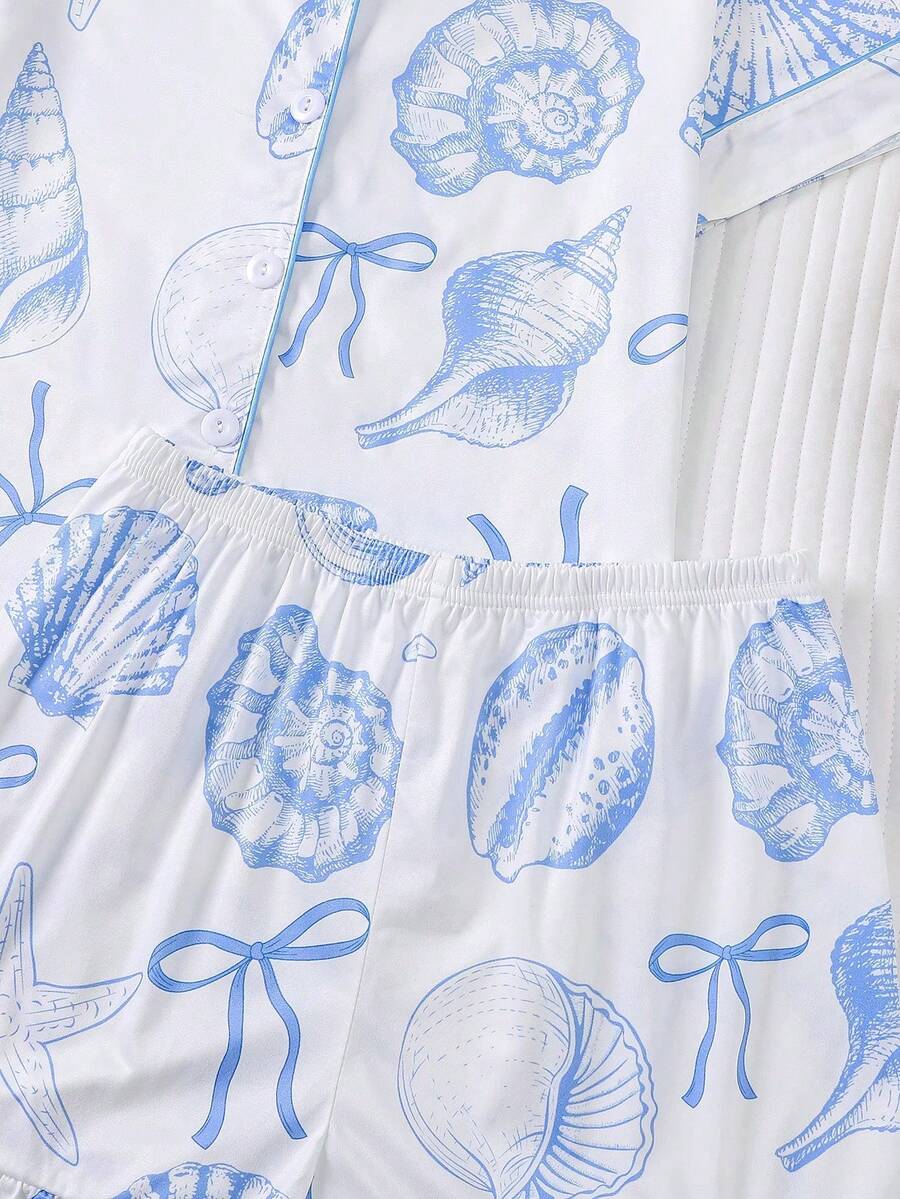 White 2-piece tween girl summer pajama set with blue ocean and seashell print featuring a short sleeve lapel cardigan top and matching elastic waist shorts.