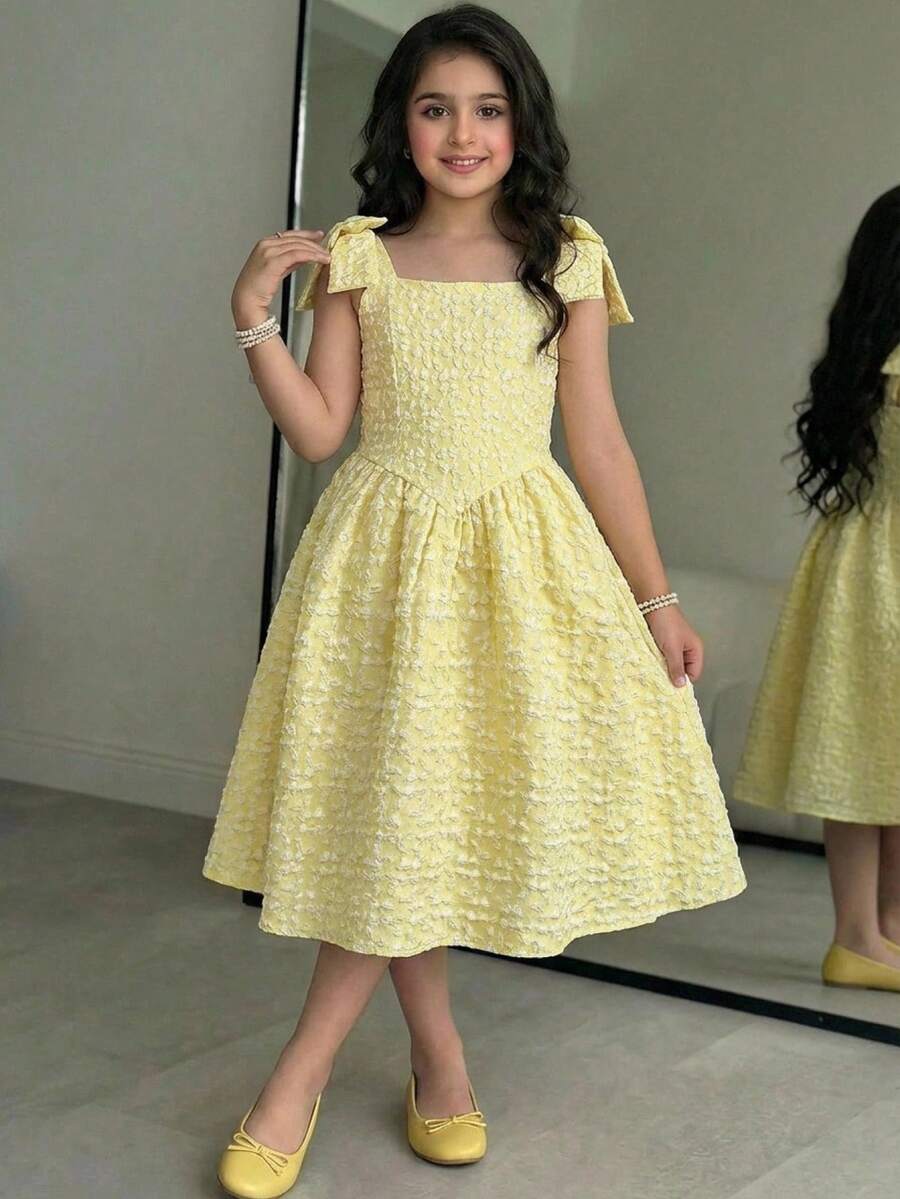 Yellow floral sleeveless A-line dress for tween girls featuring high waist, shirred detailing, and decorative bow