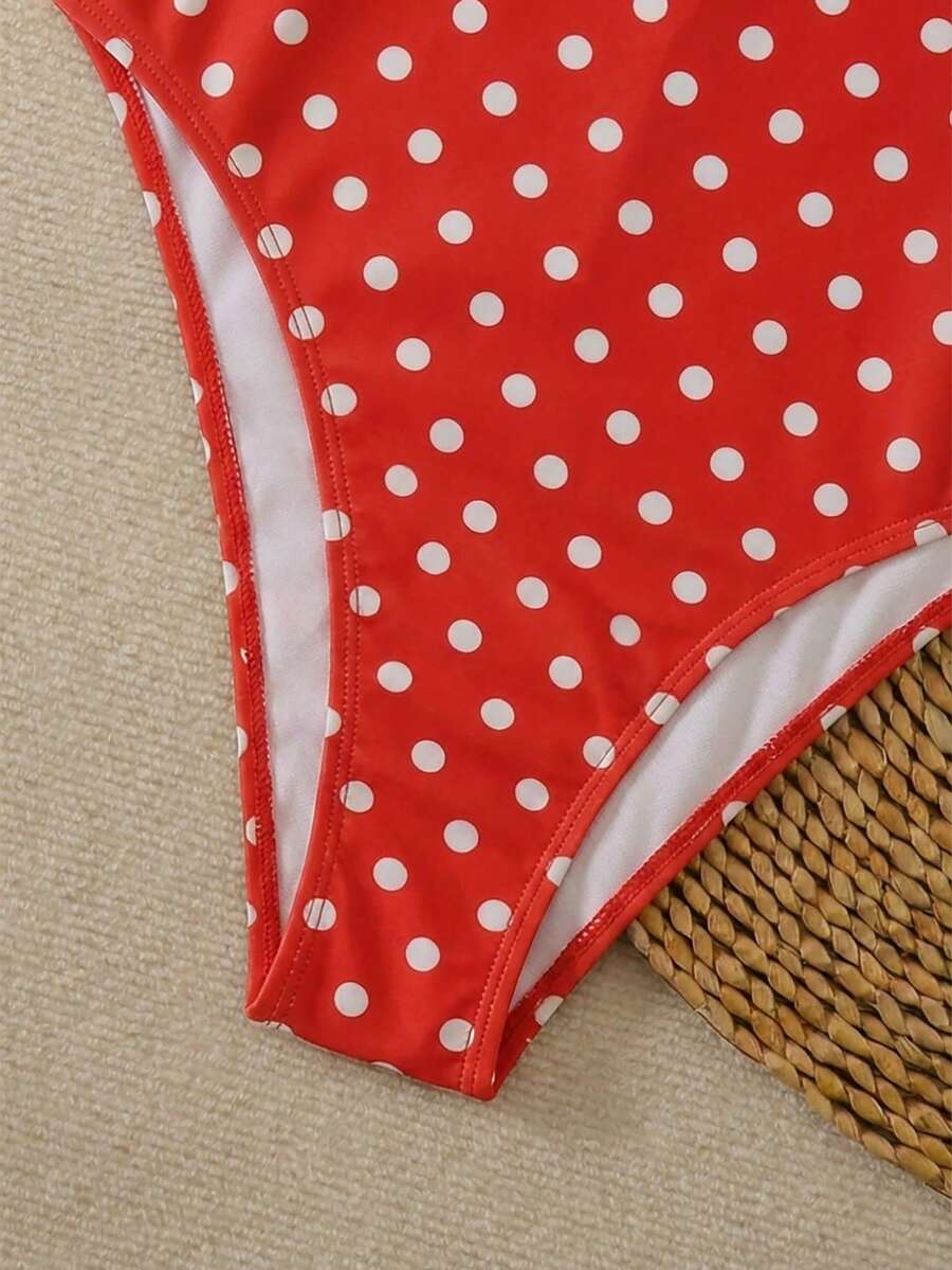 Women's apricot polka dot two-piece swimsuit featuring an asymmetrical halter backless top with knot tie detail and high-waisted bottoms.