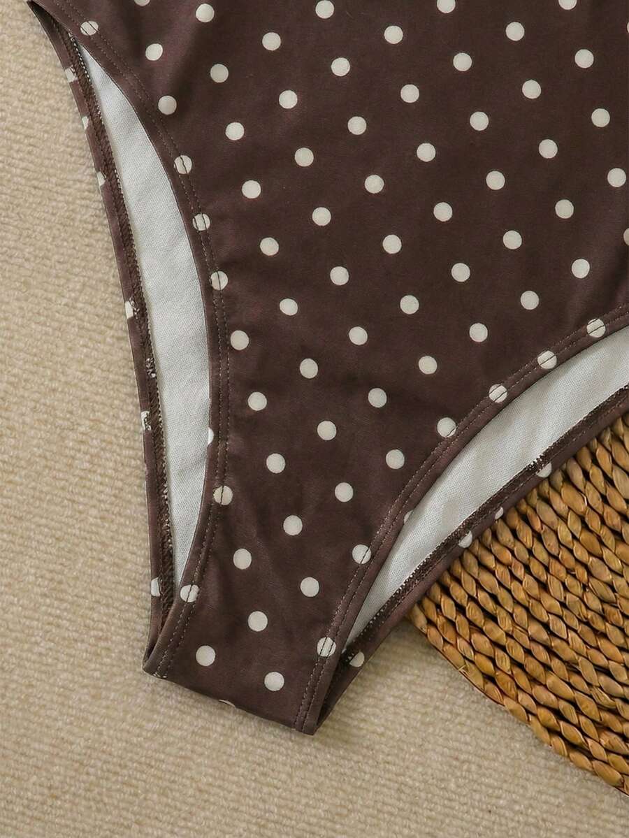 Women's apricot polka dot two-piece swimsuit featuring an asymmetrical halter backless top with knot tie detail and high-waisted bottoms.