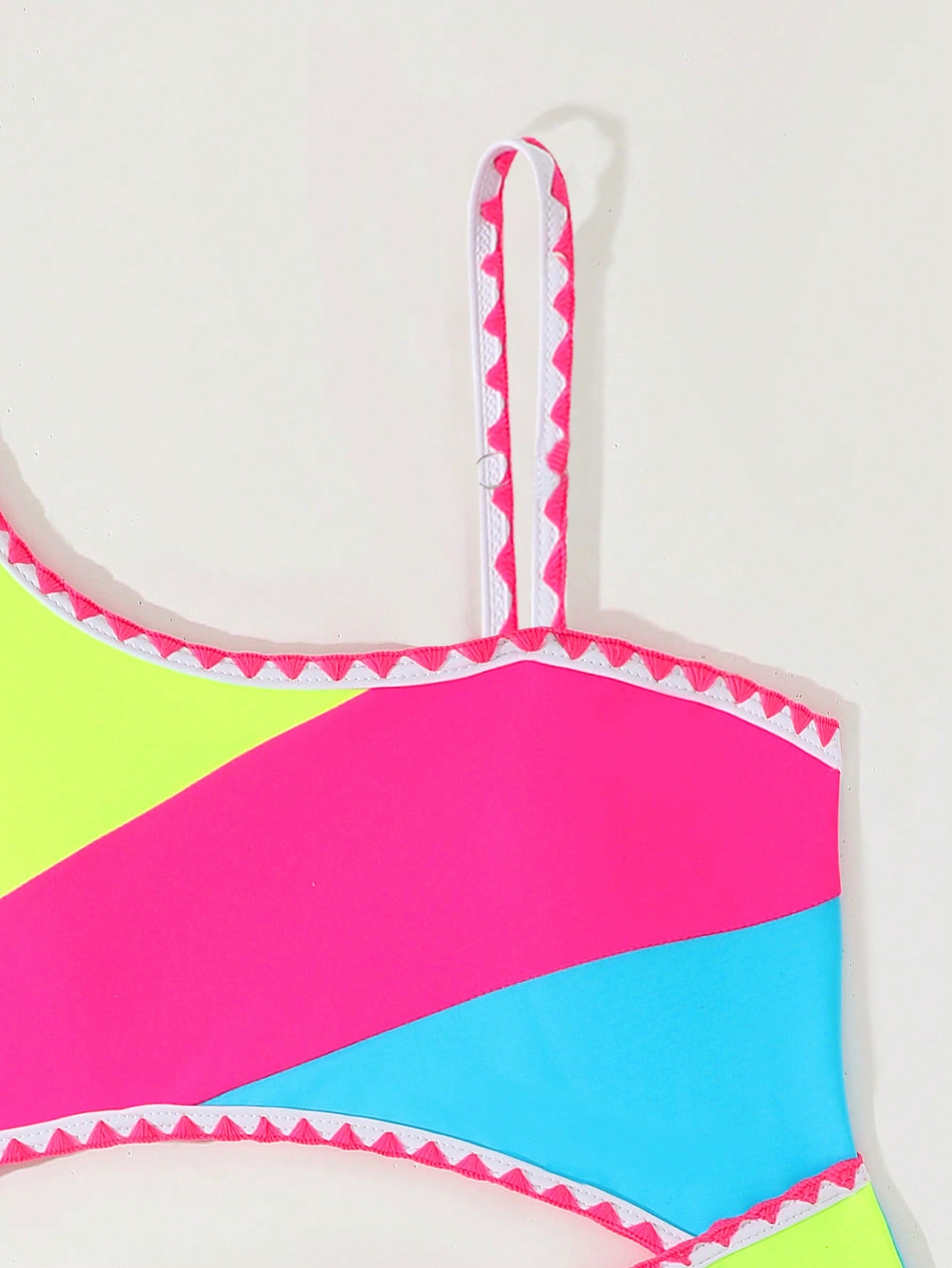 Tween girls one-piece swimsuit featuring an asymmetric neckline, pendant decor, plain design, wireless bra, high-cut bottom, and medium-stretch fabric.