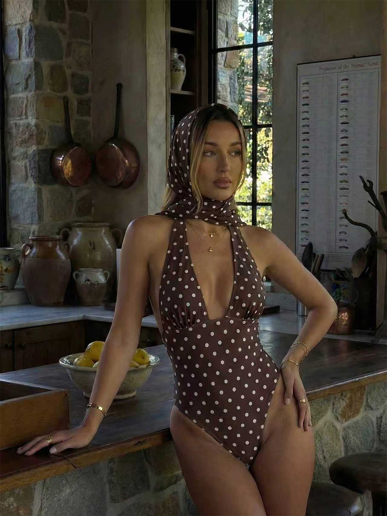 Women's apricot polka dot two-piece swimsuit featuring an asymmetrical halter backless top with knot tie detail and high-waisted bottoms.
