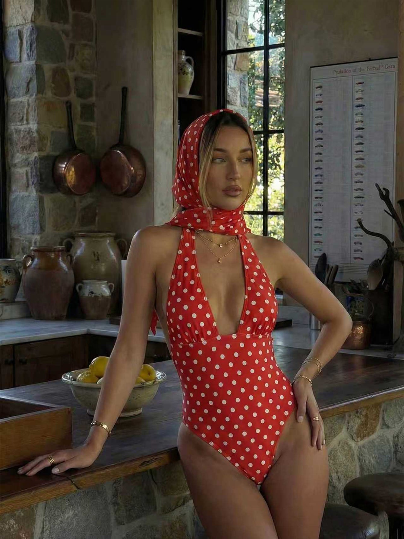 Women's apricot polka dot two-piece swimsuit featuring an asymmetrical halter backless top with knot tie detail and high-waisted bottoms.