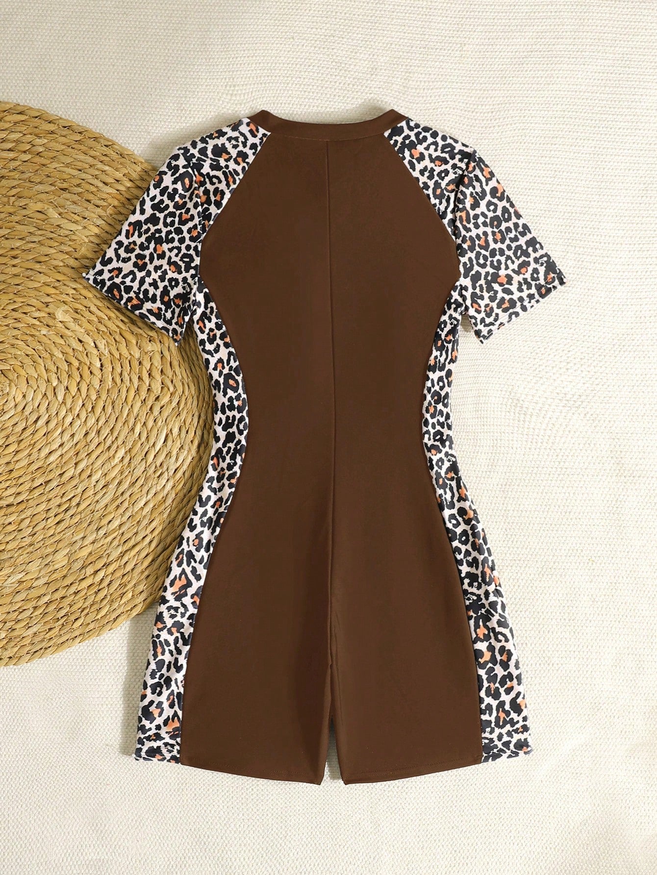 Black and white one-piece rashguard swimsuit for tween girls with short sleeves, high neck, zipper detail, fitted shape, and shorts-style bottom.
