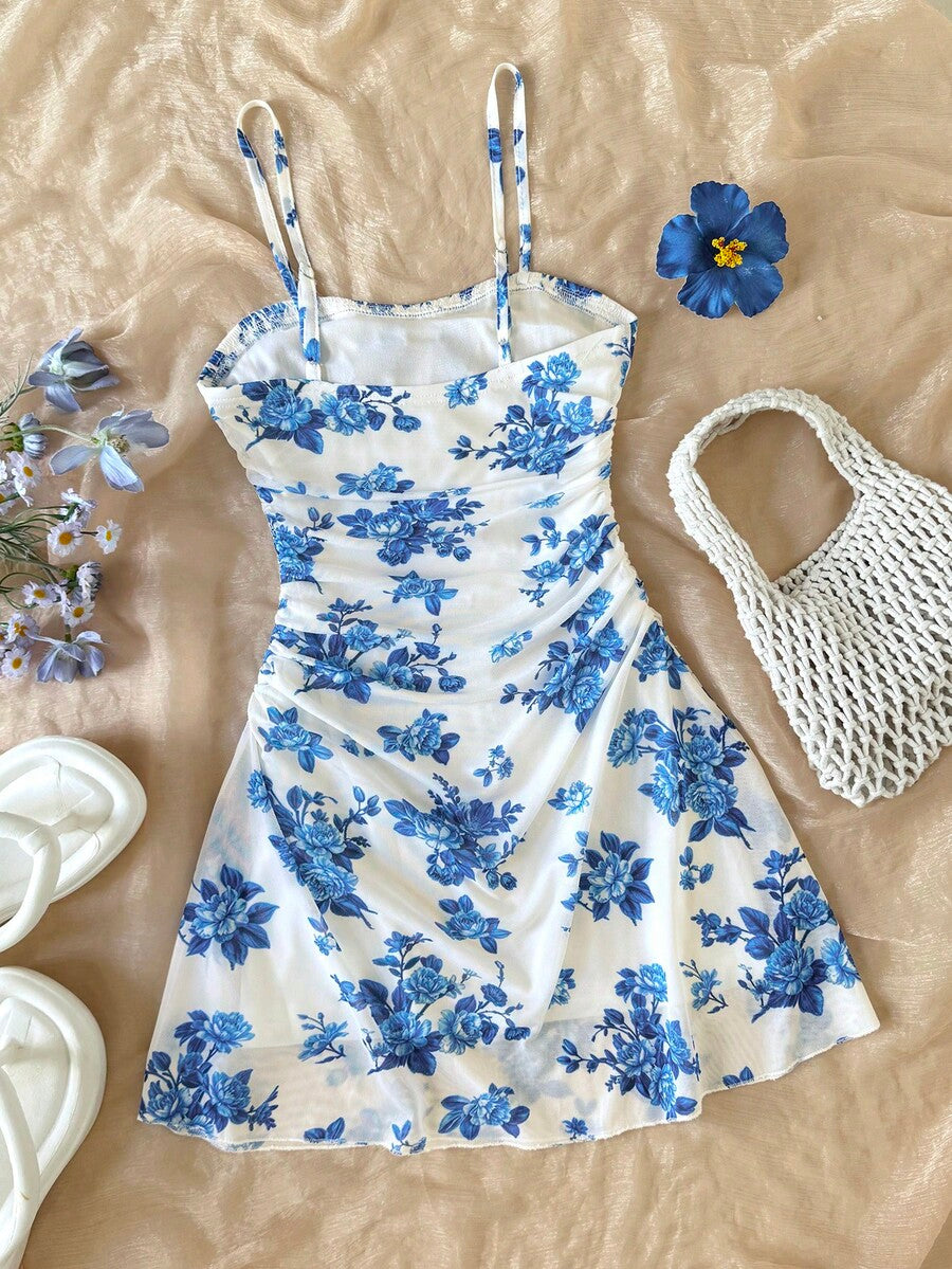 Tween girl yellow mini sundress with large pink floral hibiscus print, spaghetti straps, high waist, flared hem, and sleeveless cami style for summer beach wear